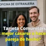 Pareja sonriente frente a la Oficina de Extranjería tras obtener su tarjeta comunitaria