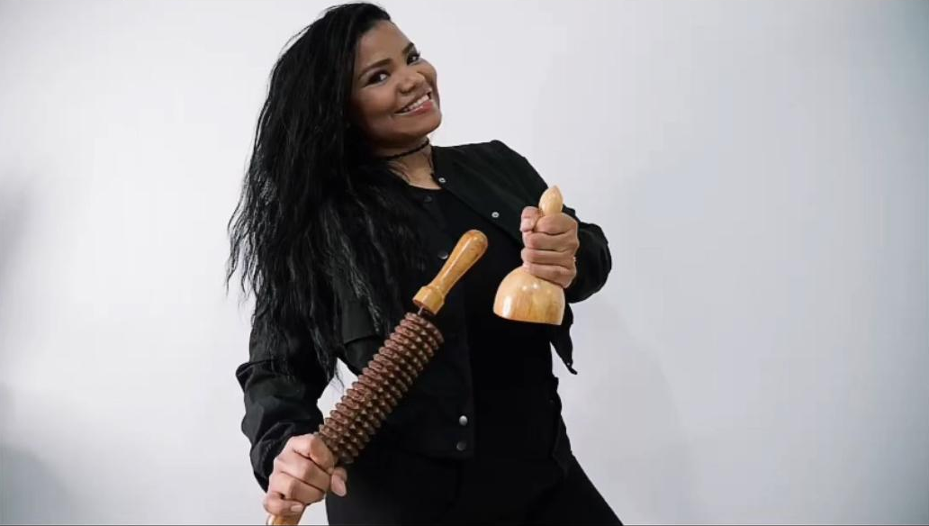 esteticista colombiana en Avilés mostrando herramientas de maderoterapia con una gran sonrisa